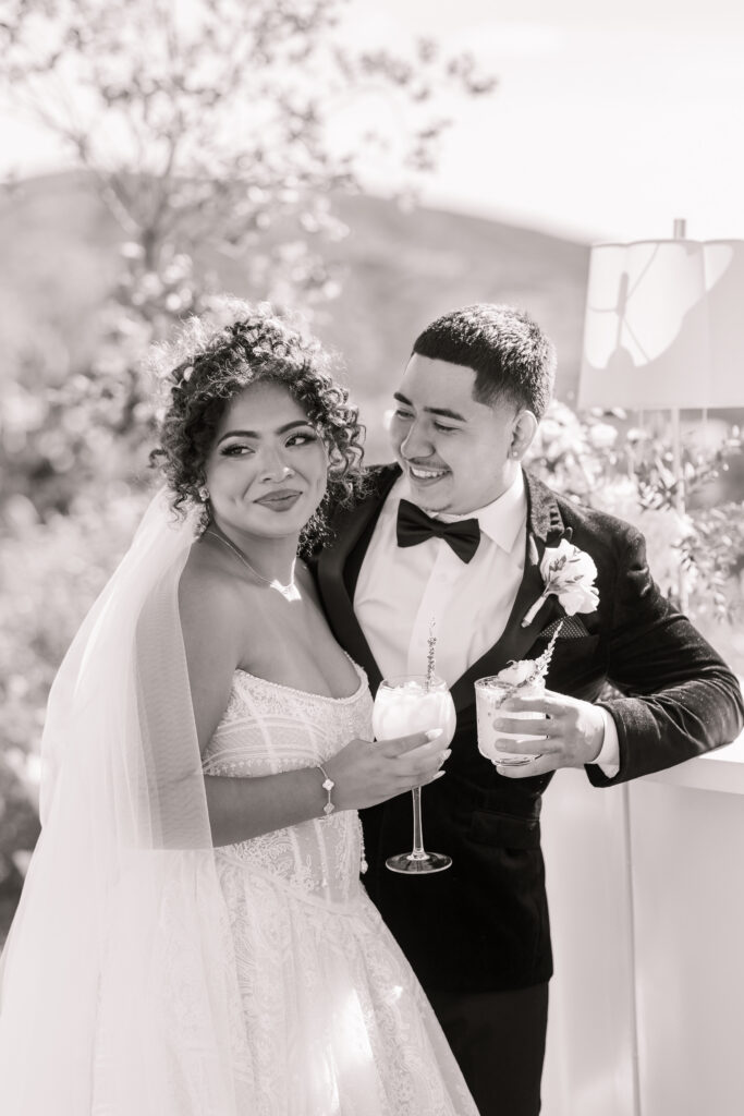 Black and white image of bride and groom enjoying cocktail hour signature drinks at The Hillside Estate.