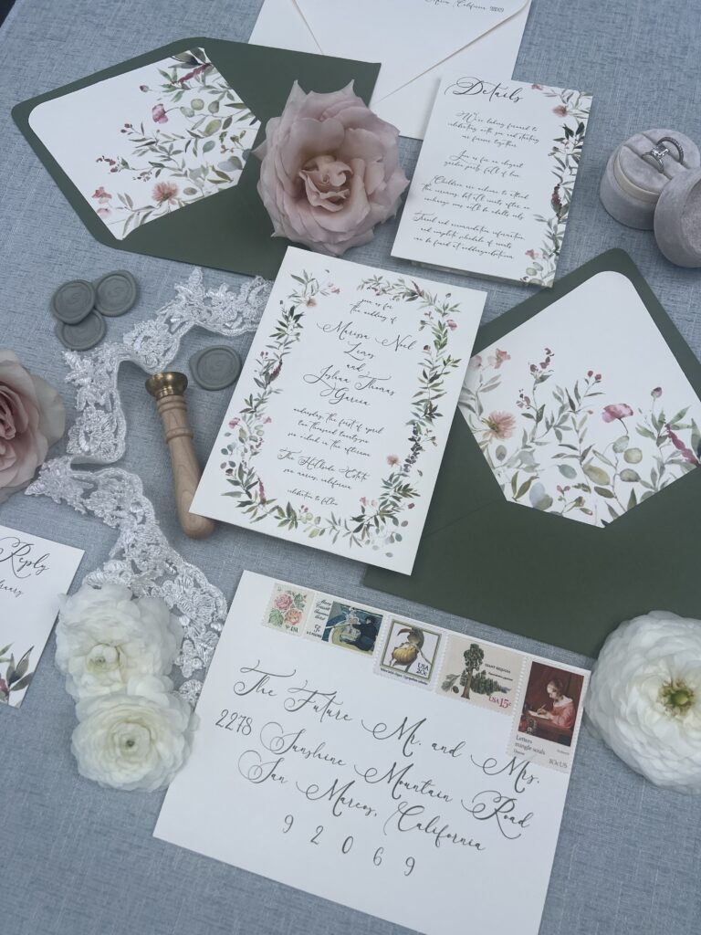Wedding invitation suite with watercolor flowers, sage green envelopes, wax seals, and calligraphy addressing with vintage postage designed by Beach City Creative for a wedding at The Hillside Estate.