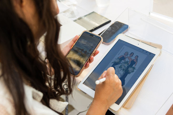 Live sketch artist drawing a digital portrait of bride and bridesmaids on a tablet at a Hilton San Diego Bayfront wedding reception