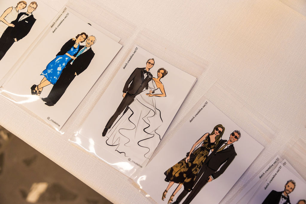 Printed digital portrait illustrations created by a live sketch artist at a Hilton San Diego Bayfront wedding reception, displayed as personalized take-home favors for guests